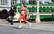 Shannon-Rowbury;professional-runner;athlete;5000-meters;1500-meters;bronze-medalist;olypmian;female;woman;Nike;sponsored;urban;San-Francisco;wharf;clock-tower;trolley;green;orange;training;city;speed;fast;motion;panning
